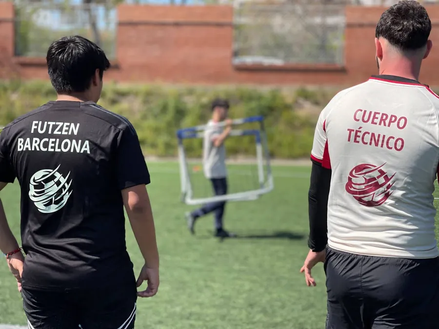 Un jugador y un entrenador de FUTZEN de espaldas en el campo