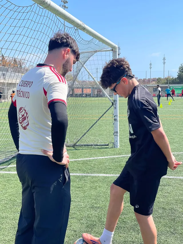 Un entrenador de FUTZEN corrige la técnica de un jugador junto a la portería