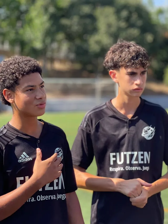 Dos jugadores de FUTZEN escuchan con calma; uno se lleva la mano al pecho