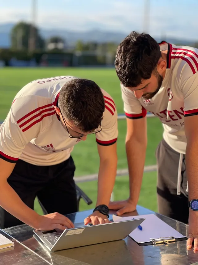 Dos entrenadores de FUTZEN revisan el plan de un jugador en el portátil
