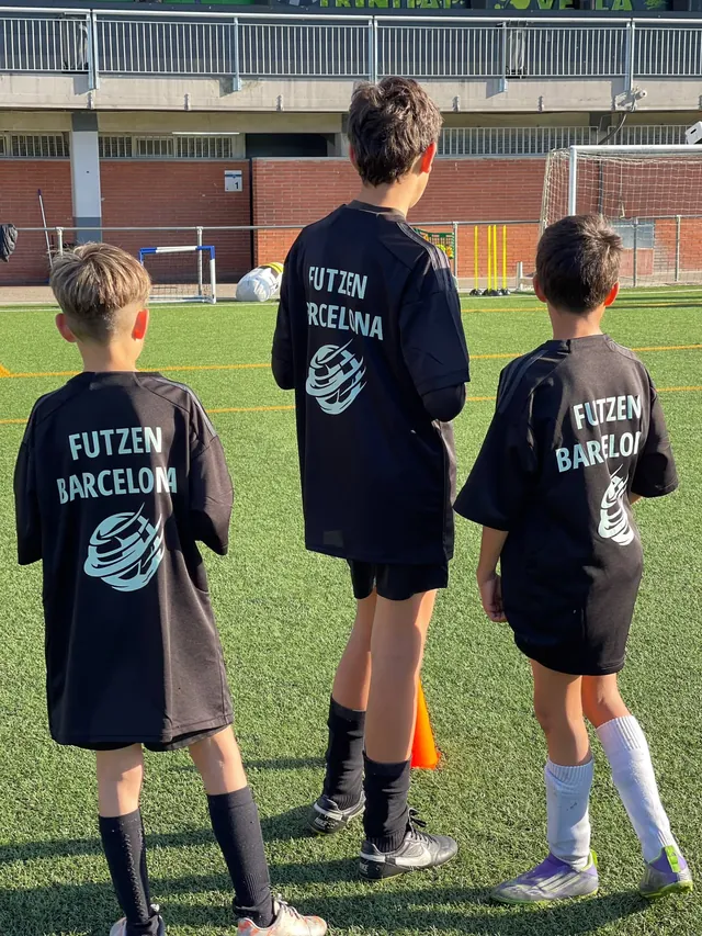Tres niños de espaldas con la camiseta FUTZEN Barcelona